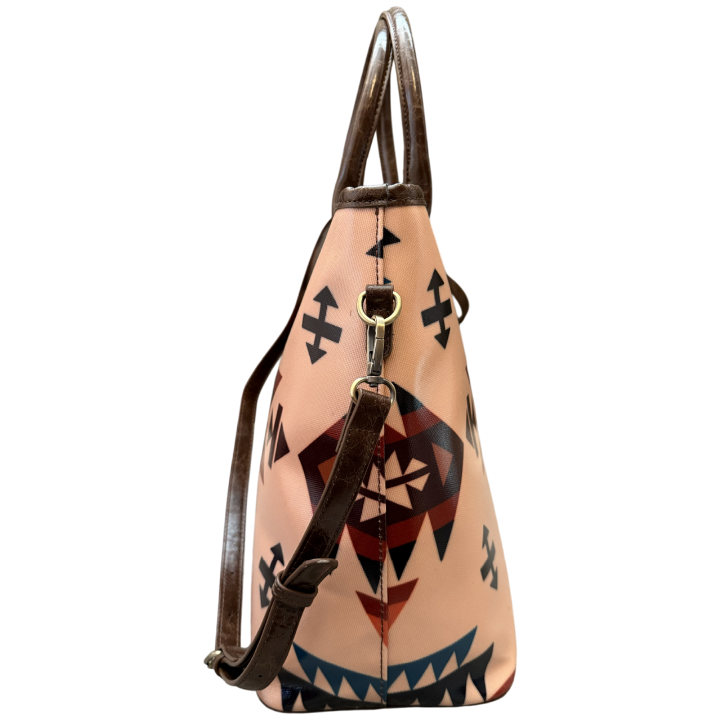 A structured leather shoulder bag with a light peach-beige body featuring a Southwestern geometric pattern in black, red, and blue, with dark brown leather handles and strap.