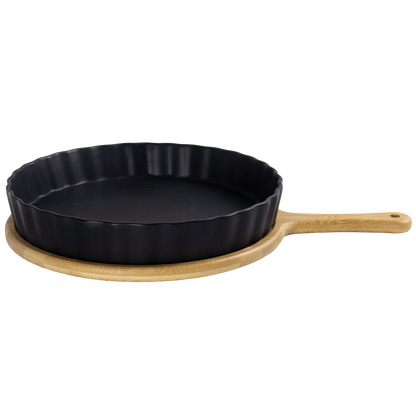 Black cast iron skillet with bamboo holder with handle on a white background