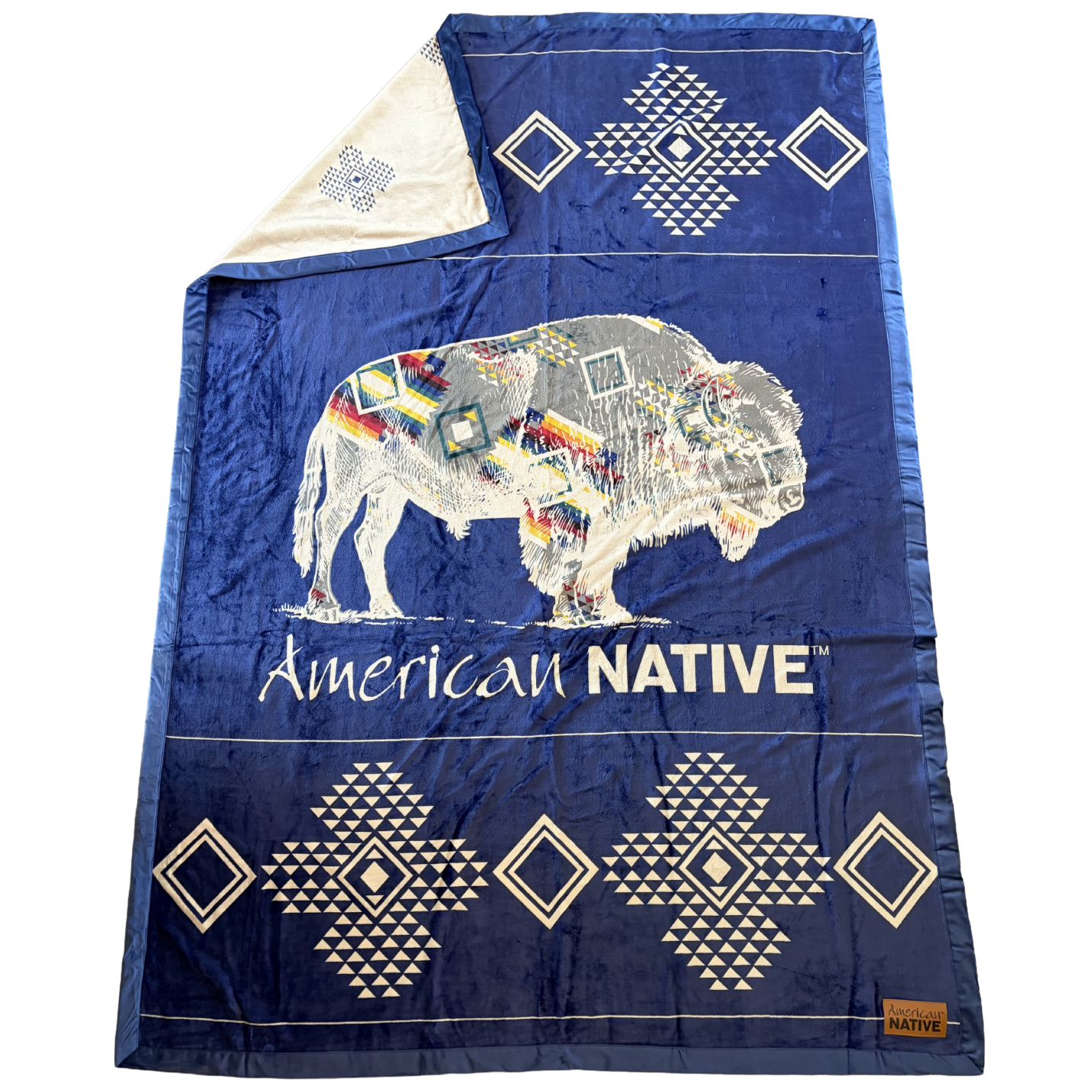 Blue blanket with a colorful bison design and 'American Native' text on a white background