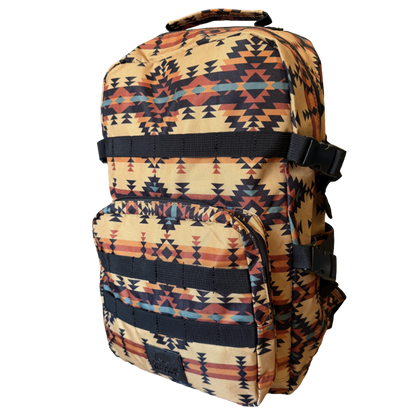 A backpack with a Southwestern geometric pattern in beige, black, orange, and blue, featuring a top carry handle and front utility pockets, shown against a plain white background.