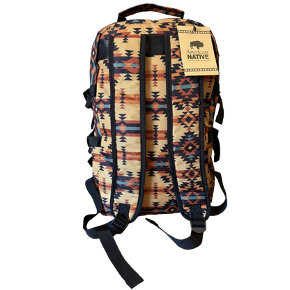 A backpack with a Southwestern geometric pattern in beige, orange, blue, and black, featuring a tan leather brand patch that reads 'SOUTH WIND NATIVE'.