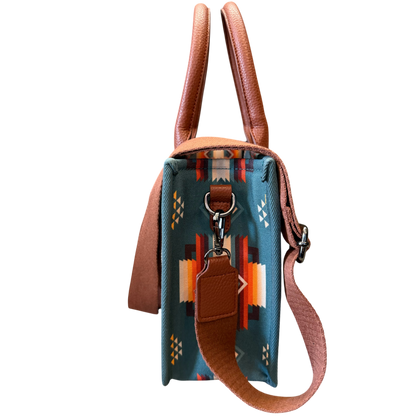 Small blue handbag with brown leather strap and handle on a white background