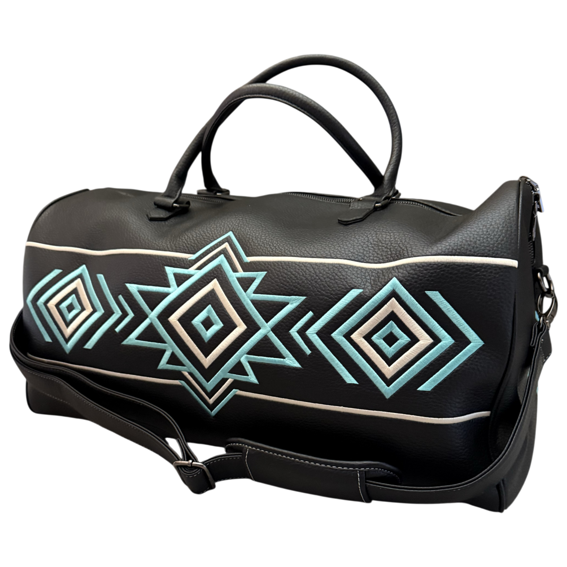 A black faux-leather duffel bag with a geometric Southwestern-style diamond pattern in turquoise, cream, and white, featuring dual top handles and a detachable shoulder strap.