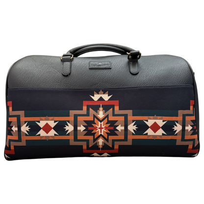 A dark gray leather duffel bag featuring a prominent Southwestern geometric pattern in red, orange, beige, and white on the lower half, with a top handle and a small brand plaque on the front.
