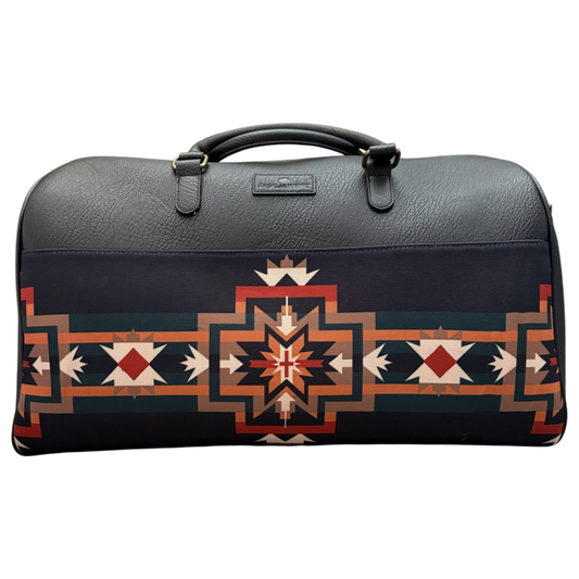 A dark gray leather duffel bag featuring a prominent Southwestern geometric pattern in red, orange, beige, and white on the lower half, with a top handle and a small brand plaque on the front.