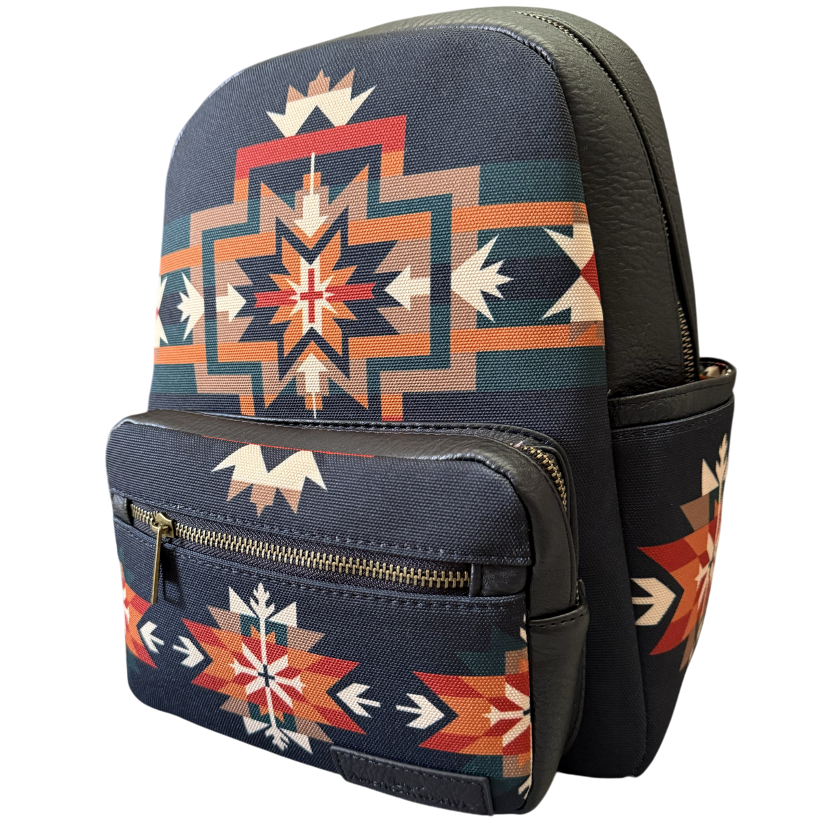 A small backpack with a navy blue base and a Southwestern geometric pattern in orange, red, beige, and teal, featuring dark brown faux-leather trim and a front zippered pocket.