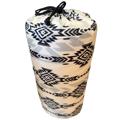  rolled-up poncho with black geometric pattern on a white background