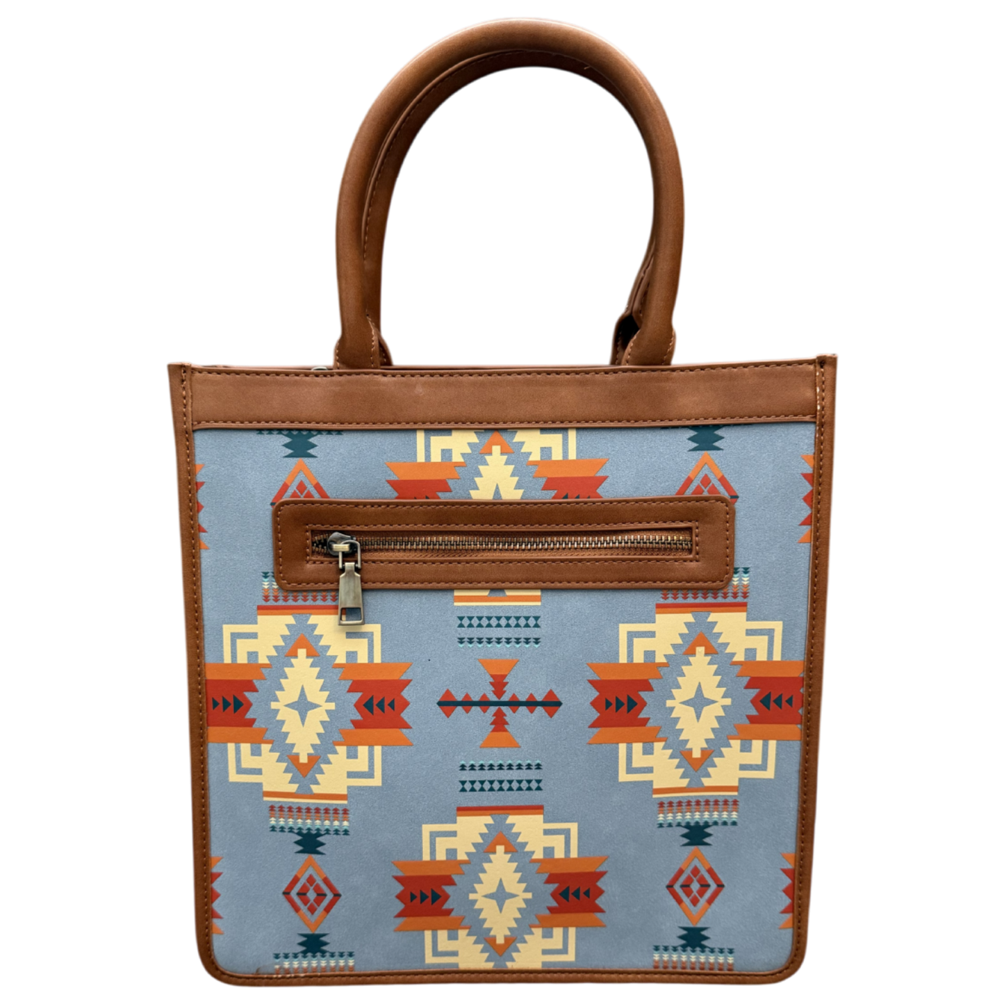 A structured tote bag with a light blue fabric body featuring a Southwestern geometric pattern in orange, red, beige, and dark blue. It has brown faux-leather trim, double top handles, and a zippered front pocket.