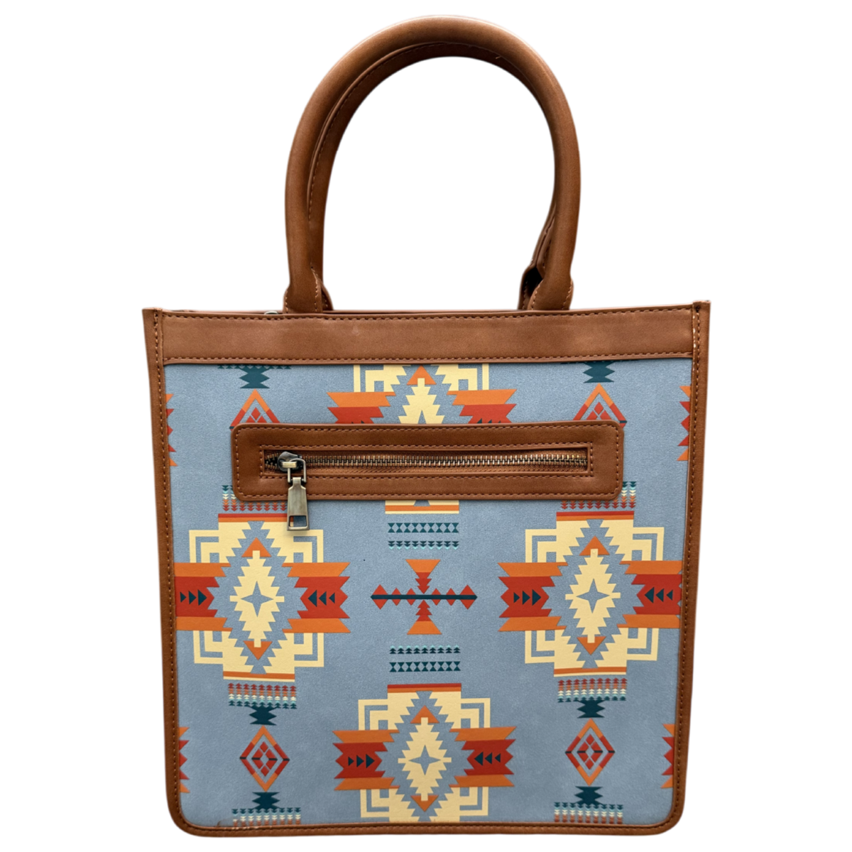 A structured tote bag with a light blue fabric body featuring a Southwestern geometric pattern in orange, red, beige, and dark blue. It has brown faux-leather trim, double top handles, and a zippered front pocket.