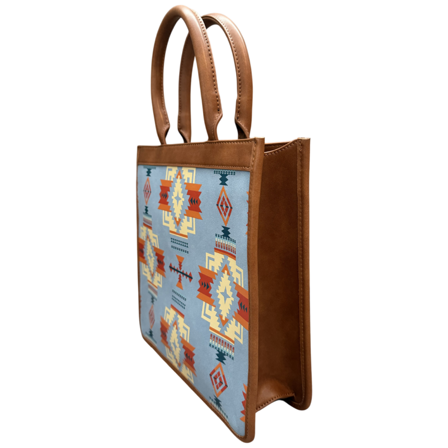 A structured tote bag with brown faux-leather handles and side panels, featuring a light blue front panel decorated with a Southwestern geometric pattern in orange, red, yellow, and dark blue.