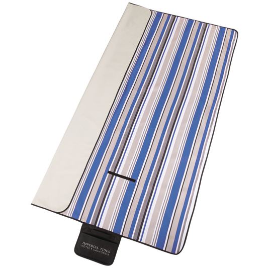 Striped picnic blanket with blue and beige pattern on a white background