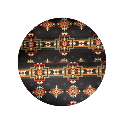 A circular fabric swatch showing a Southwestern geometric pattern on a black background with orange, red, beige, and green details.