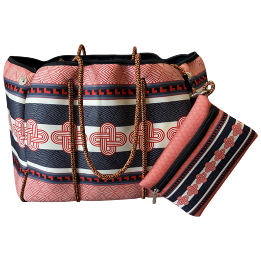 A red and black patterned tote bag with a matching zippered pouch, featuring geometric and Celtic knot designs, brown woven handles, and gold-tone hardware, shown on a plain white background.
