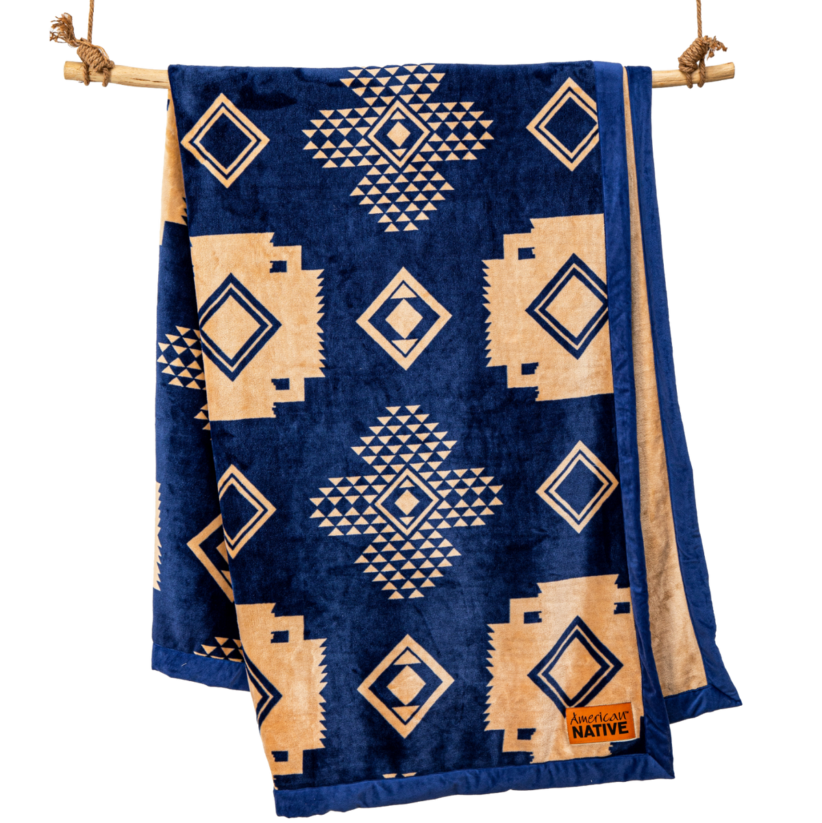 Navy blue blanket with beige geometric patterns hanging on a wooden rod.