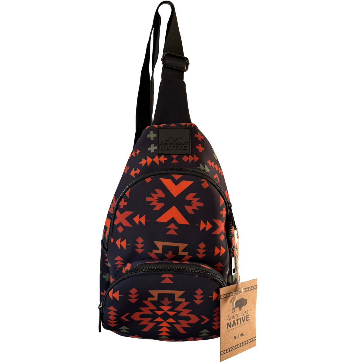 A small sling backpack with a black base and a Southwestern geometric pattern in orange, red, and brown. It features a black adjustable shoulder strap, a front zippered pocket, and a hanging paper tag that reads 'American Native'.