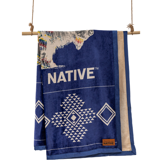 Navy and cream reversible blanket with geometric and buffalo patterns  on a wooden rod.