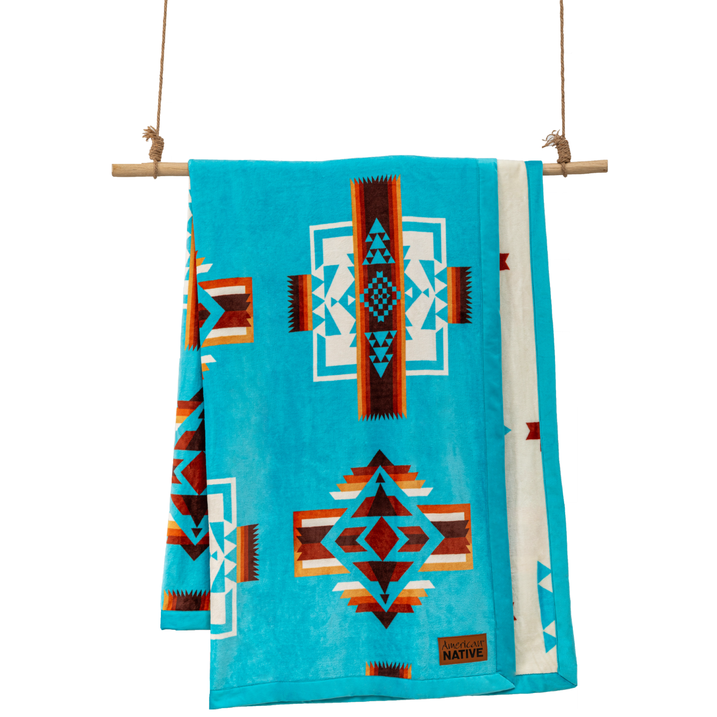 Turquoise blanket with geometric patterns hanging on a wooden rod 