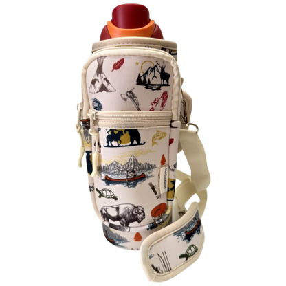 A cream-colored insulated bottle bag with a colorful outdoor-themed print of bison, mountains, and a canoe. The bag features a front zippered pocket and a matching shoulder strap, shown holding a bottle with a red cap against a plain white background.